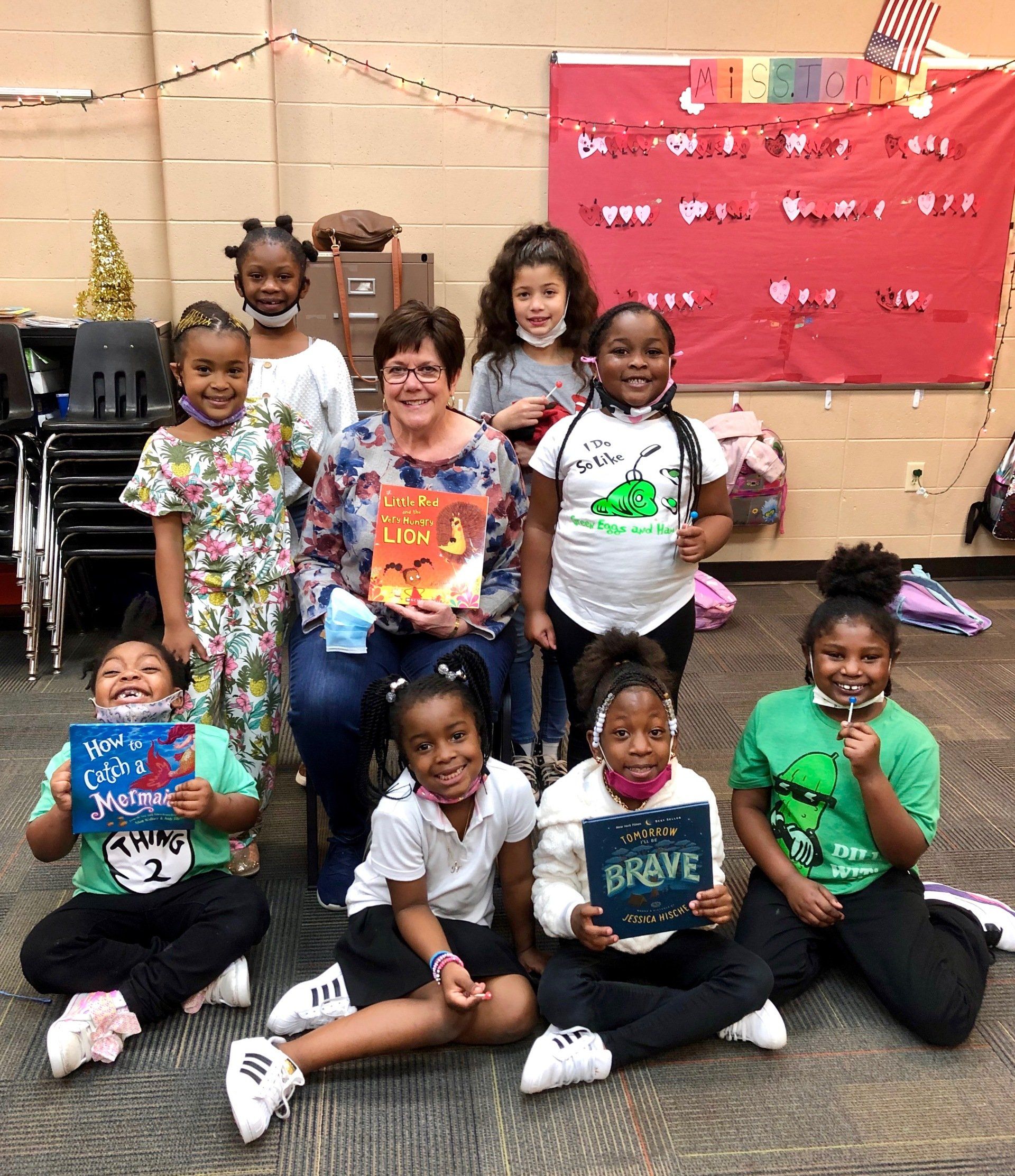 Teacher with group of children posing indoors at Boys & Girls Club