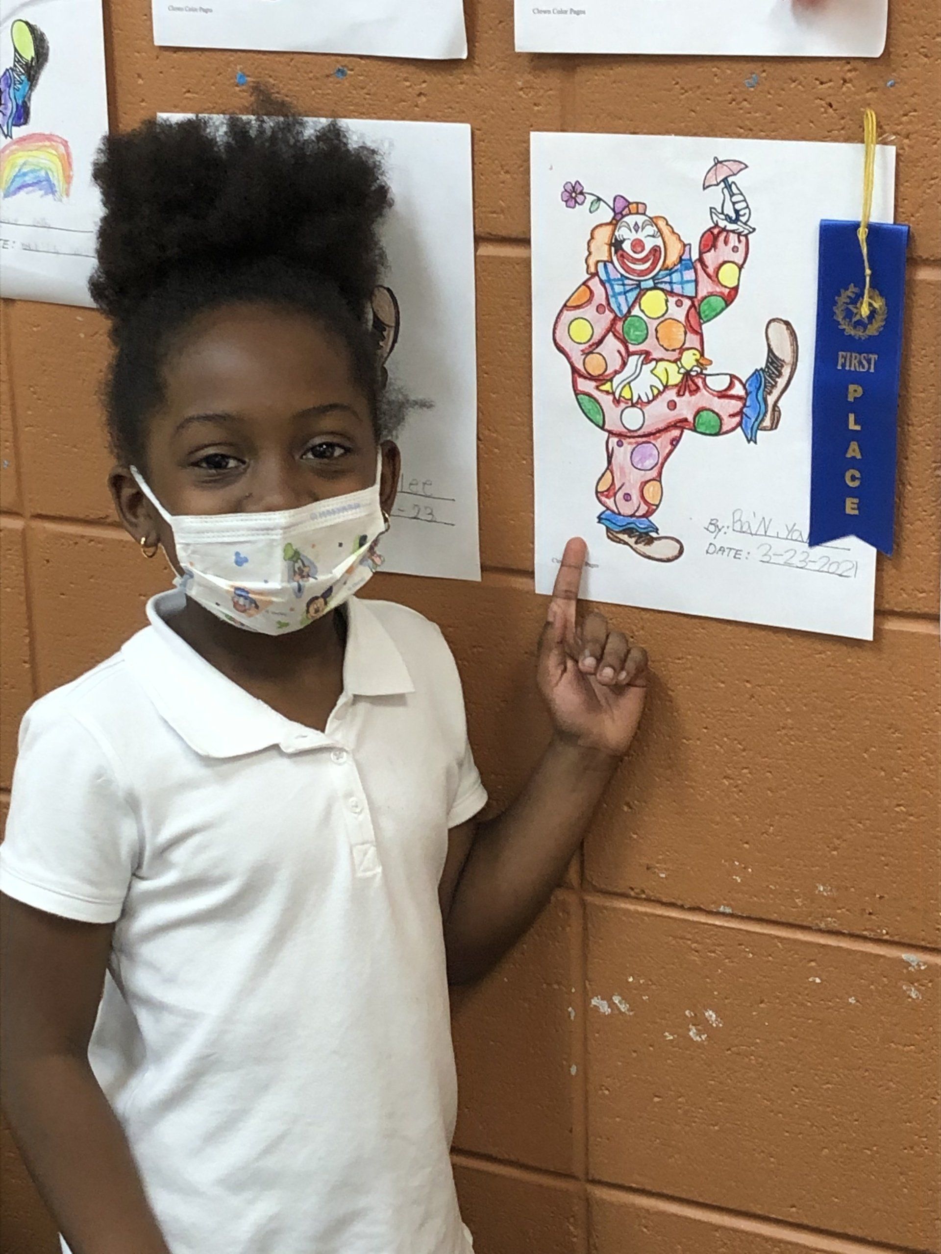 Girl smiling in front of colorful artwork at Boys & Girls Club