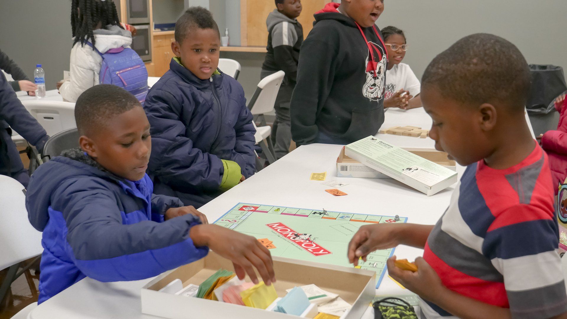 Boys playing Monopoly together in a Boys & Girls Club classroom