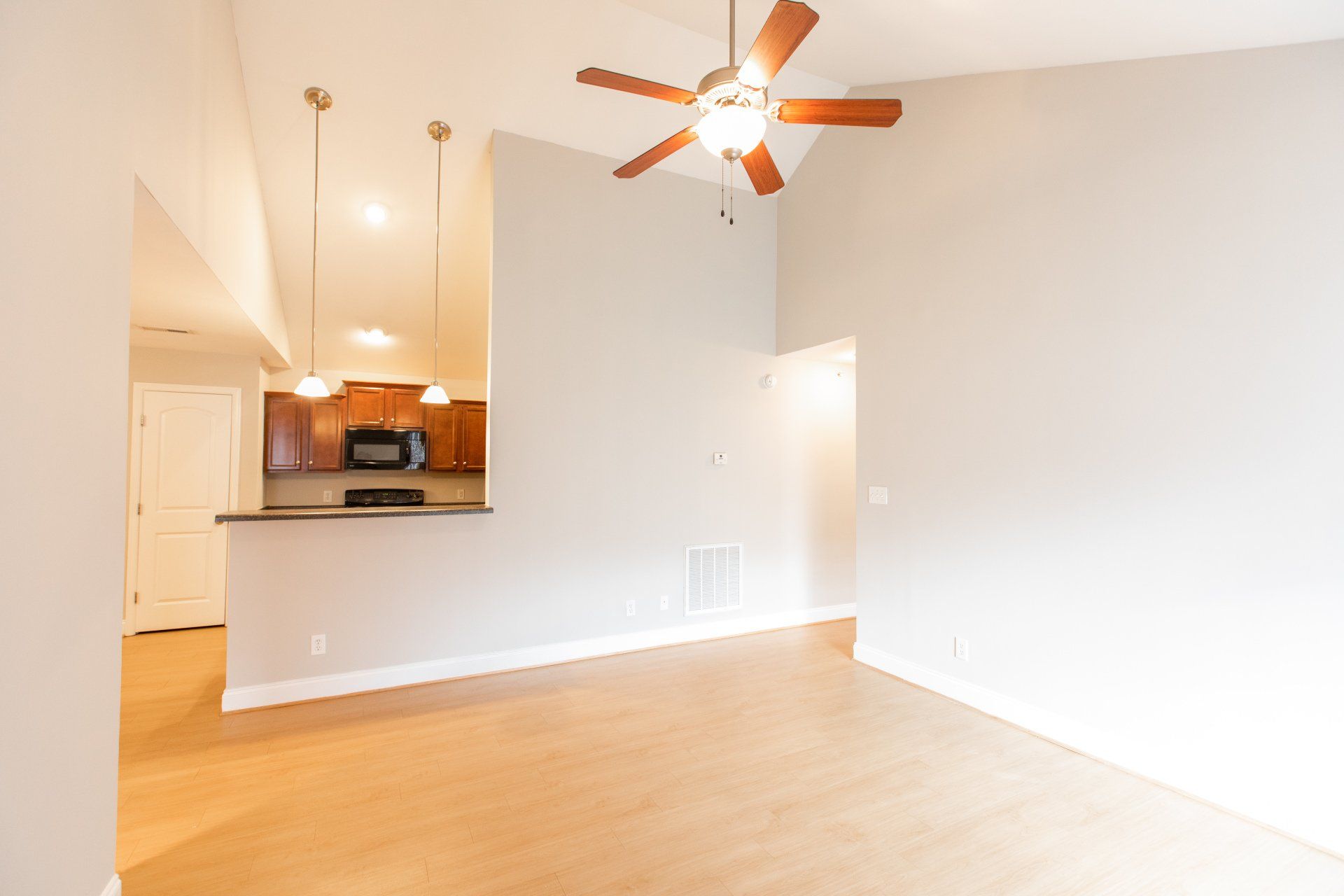 Living room with ceiling fan and view of kitchen