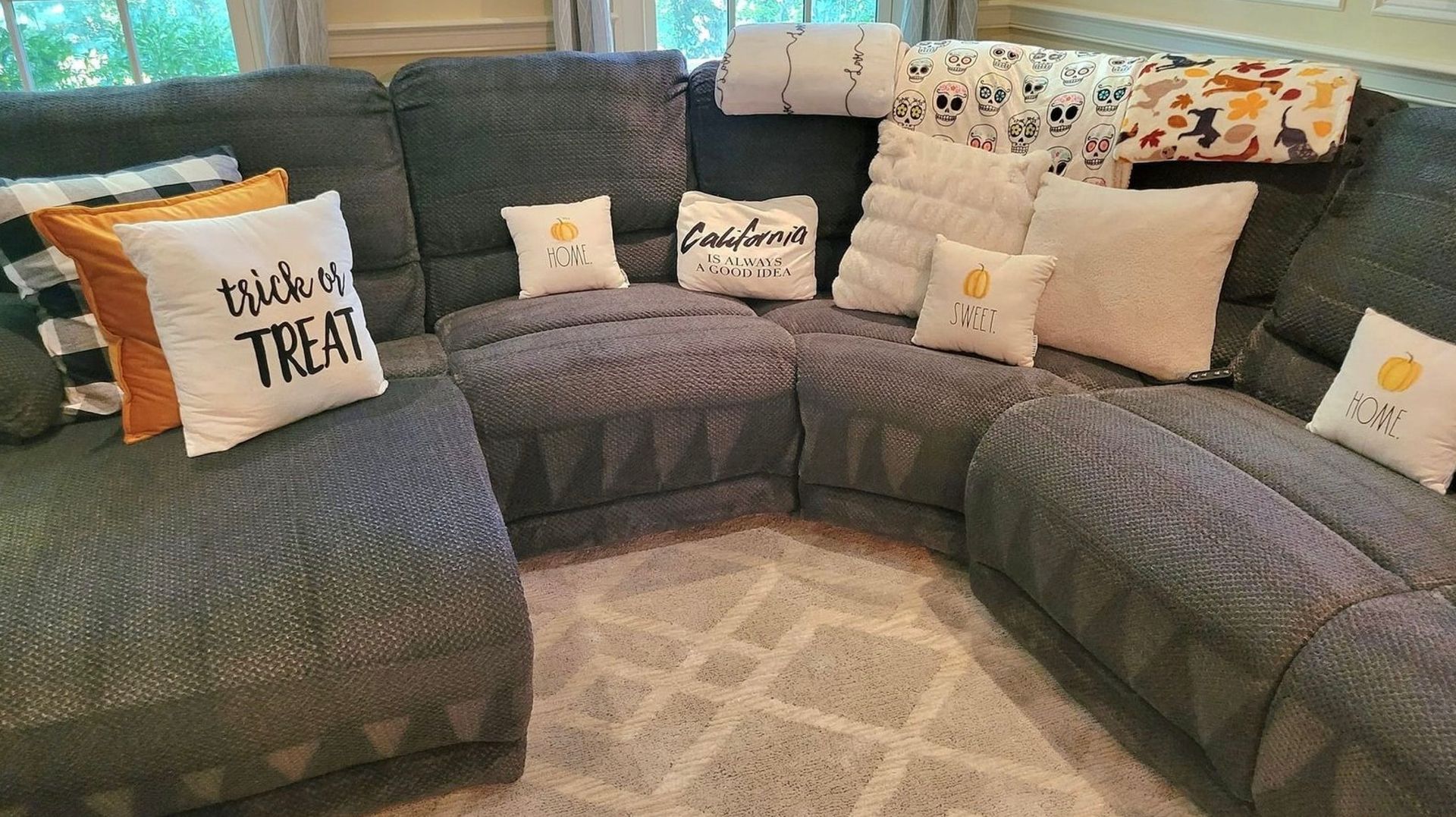 There are many pillows on the couch in the living room.