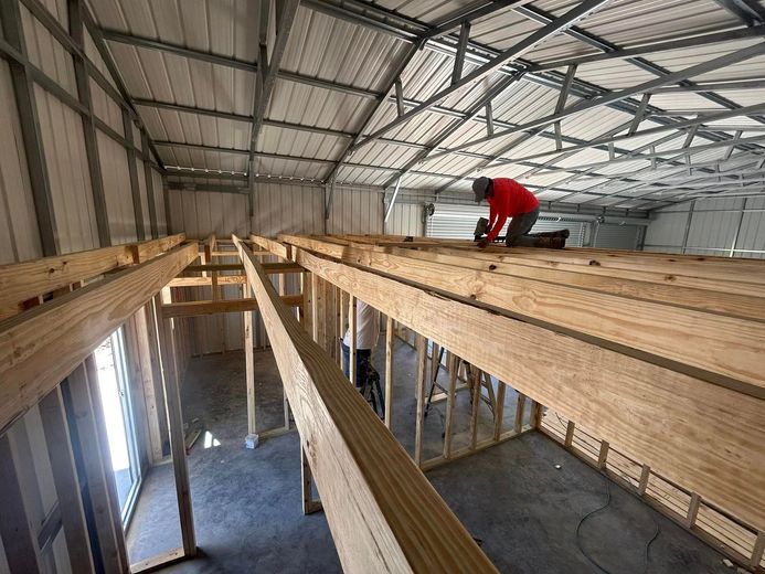 A man is working on the ceiling of a building under construction.