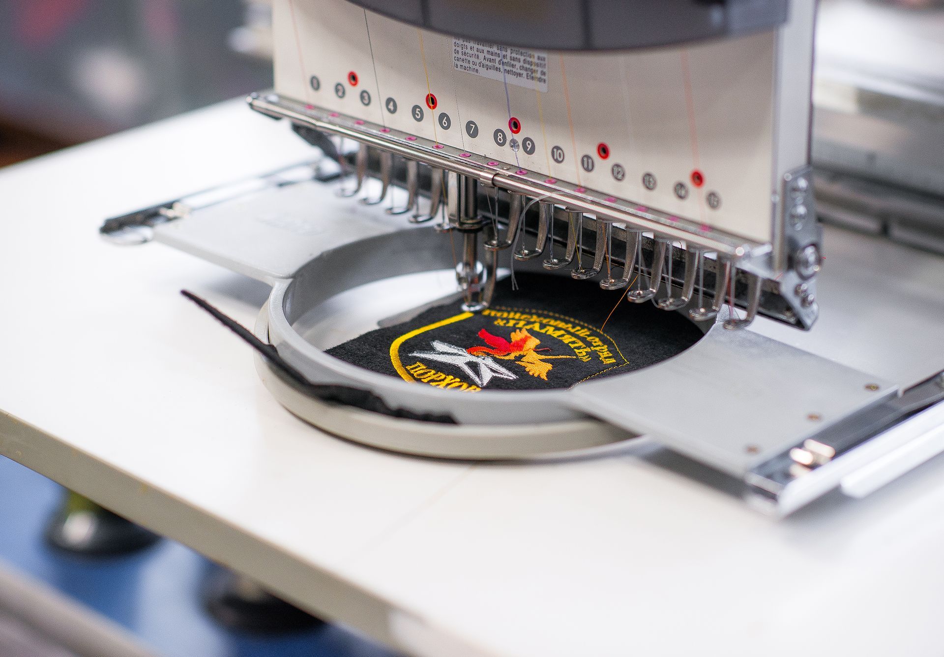 White blank fabric label stitched onto brown fabric.