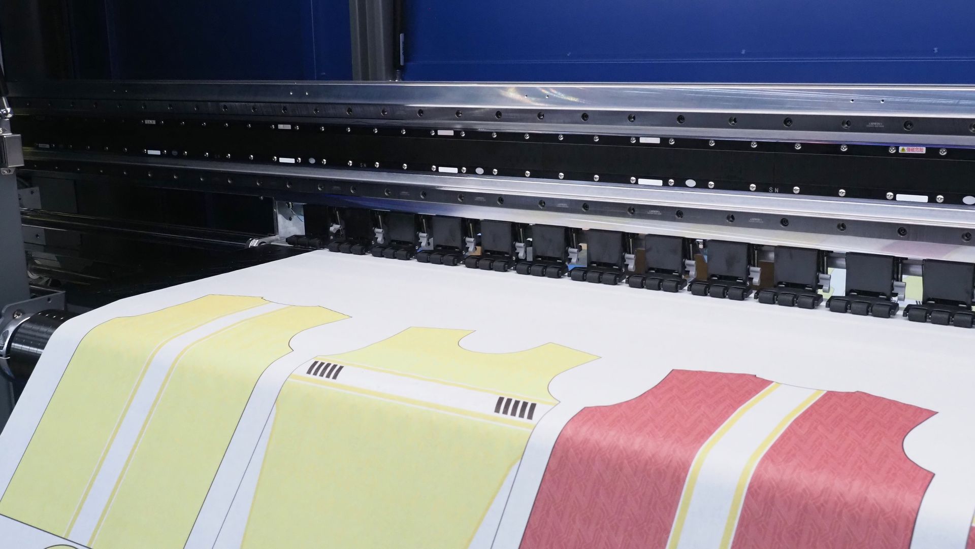 Large format printer printing colorful clothing patterns.