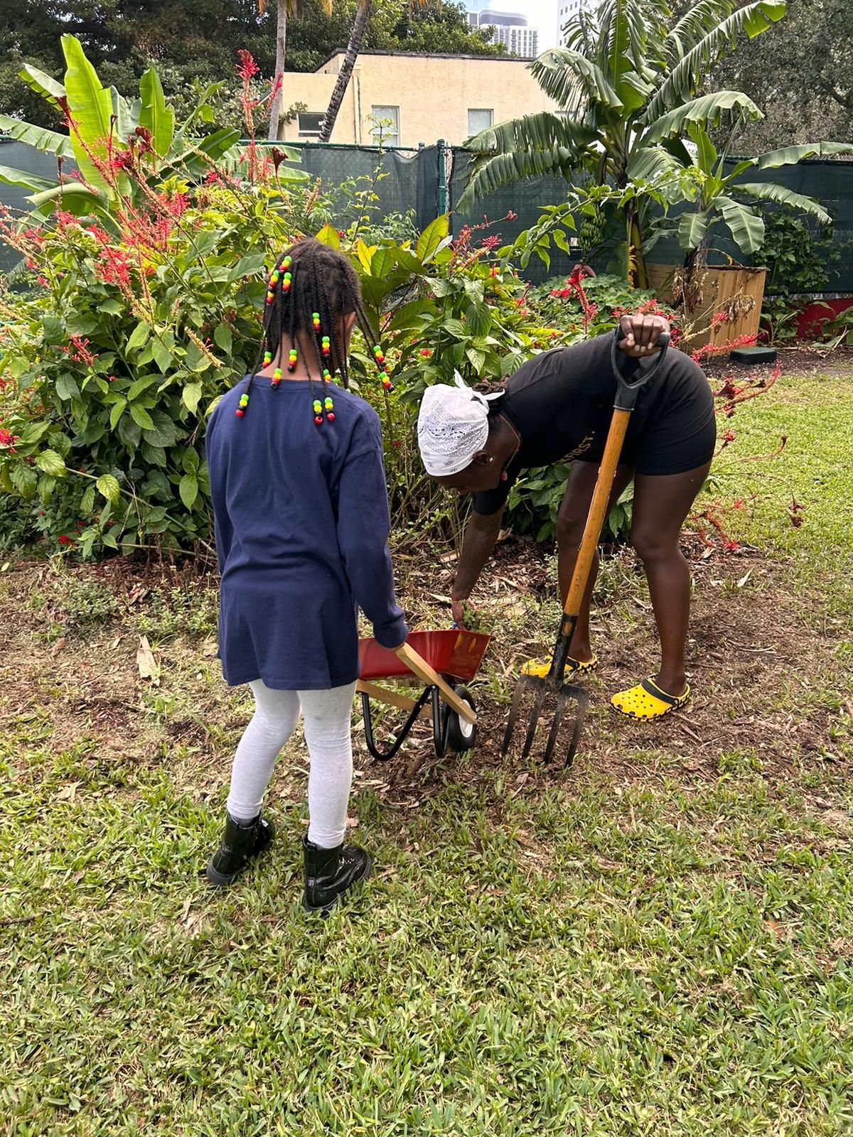 A woman and a little girl are working in a garden.