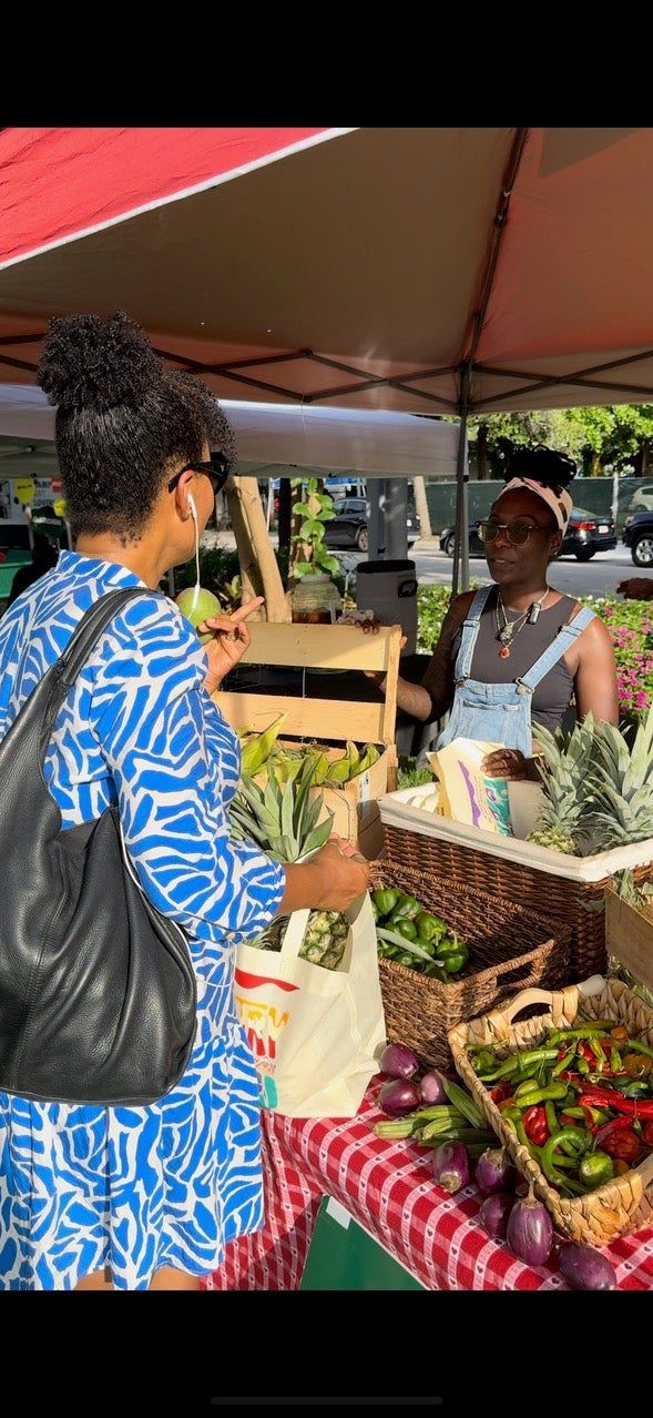 A woman is buying vegetables at a farmers market.