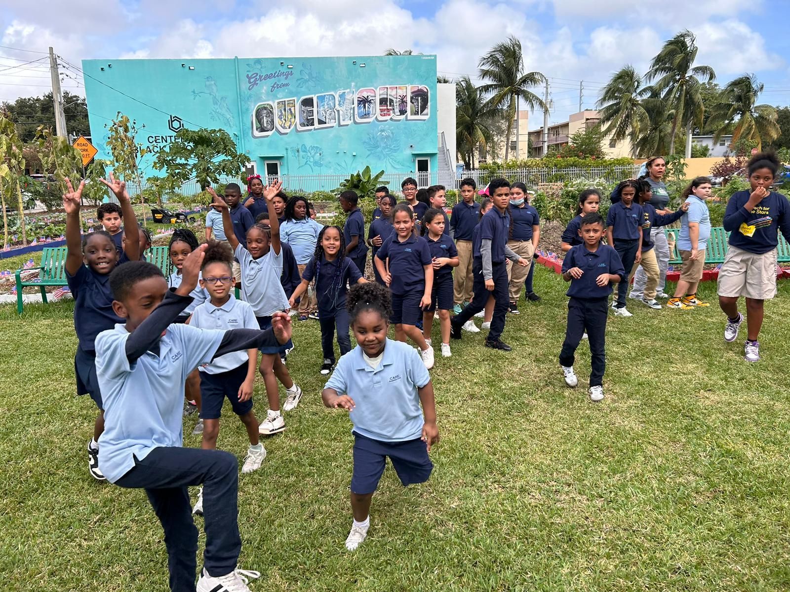 A group of children are standing in a grassy field.