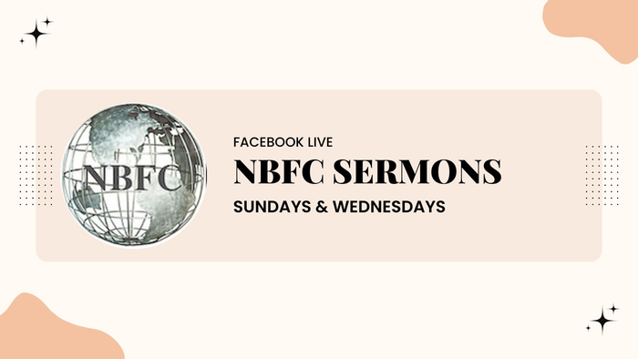 Woman with curly brown hair smiling, wearing a dark green shirt, in front of a gray wall.