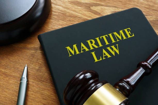 Maritime Law book with gavel and pen on wooden surface.