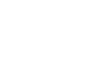 A white cat with green eyes sits perched on a tree branch, looking directly at the camera.