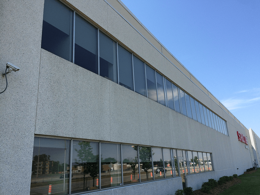 grand bâtiment en béton avec de longues fenêtres horizontales s'étendant sur tout le bâtiment