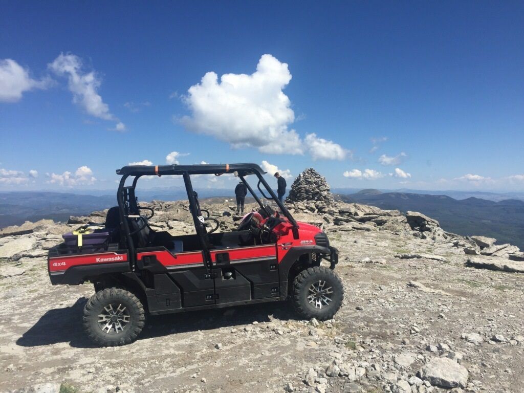 A group of people are riding atvs down a dirt road.