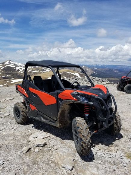 A red and black atv is parked on top of a rocky hill.