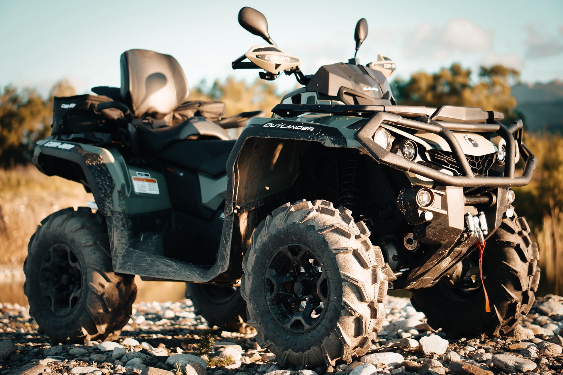 A green atv is parked on a rocky hillside.