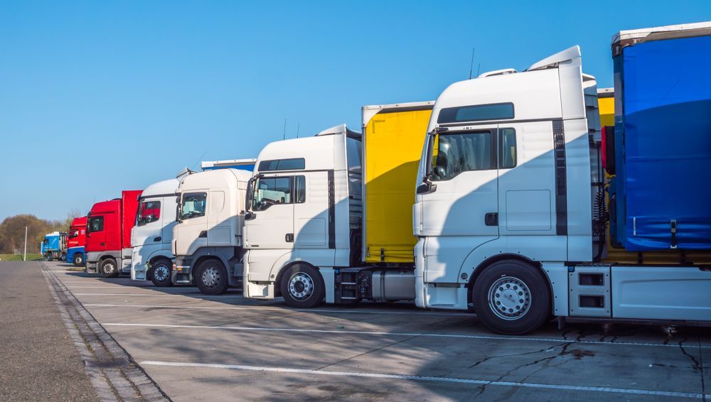 LINE of Parked Semi Trucks in Various Colors at a Loading Dock — Reliable Towing Services in Coffs Harbour, NSW