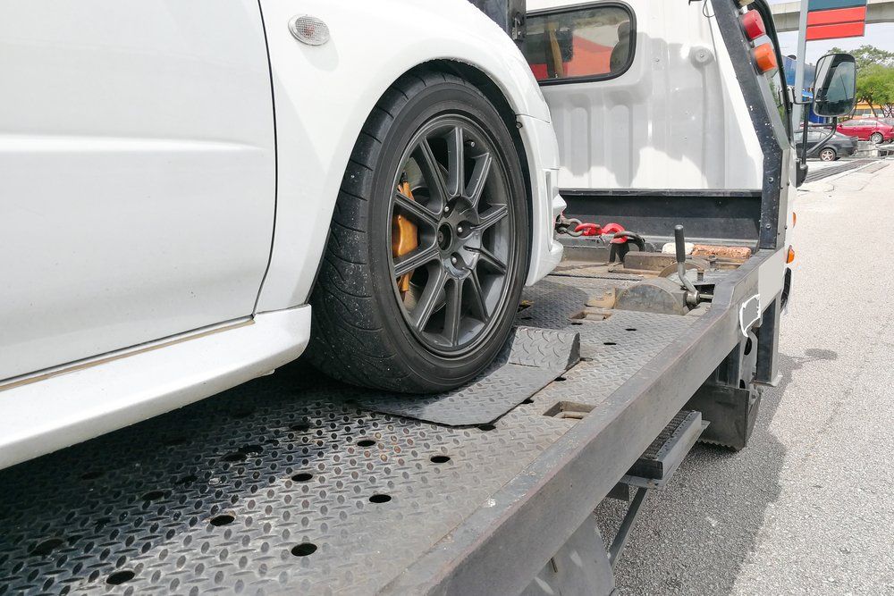 Broken Down Auto Vehicle Car Towed Onto Flatbed Tow Truck With Hook and Chain — Reliable Towing Services in Coffs Harbour, NSW