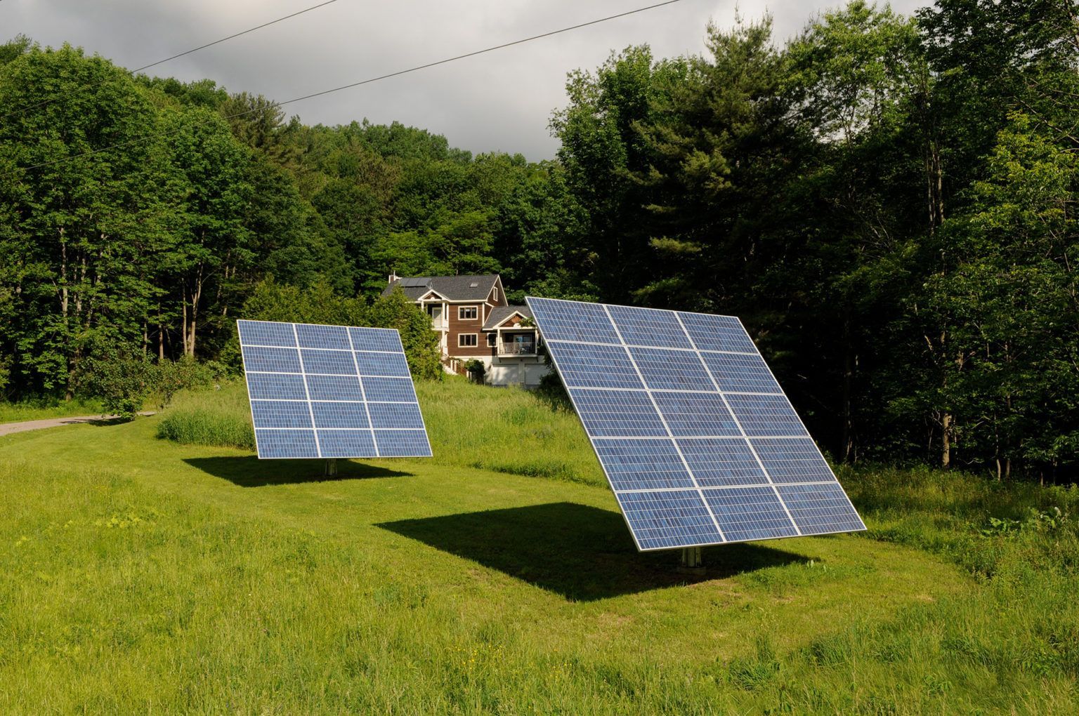 A row of solar panels sitting on top of a dirt field.