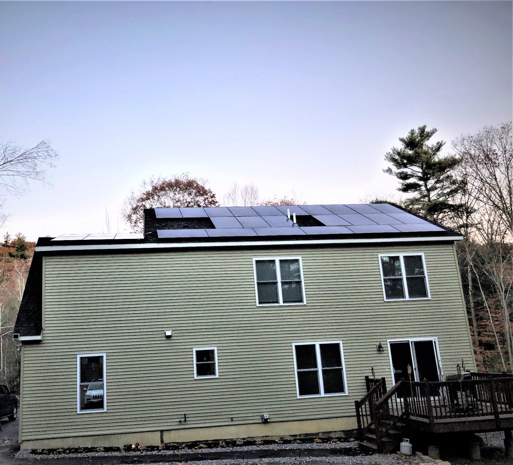 A large green house with solar panels on the roof.