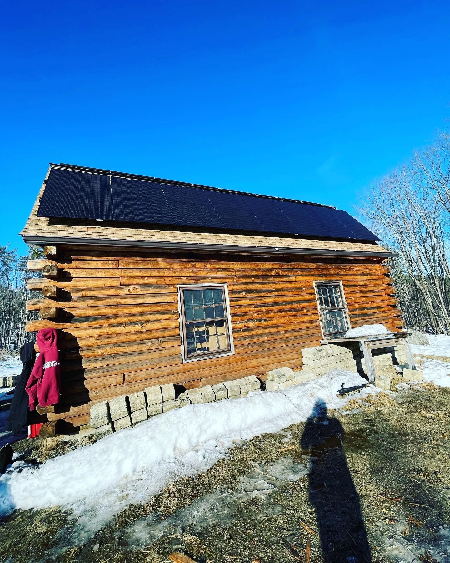 A log cabin with solar panels on the roof.