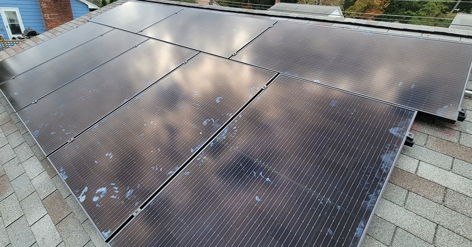 A bunch of solar panels are sitting on top of a roof.