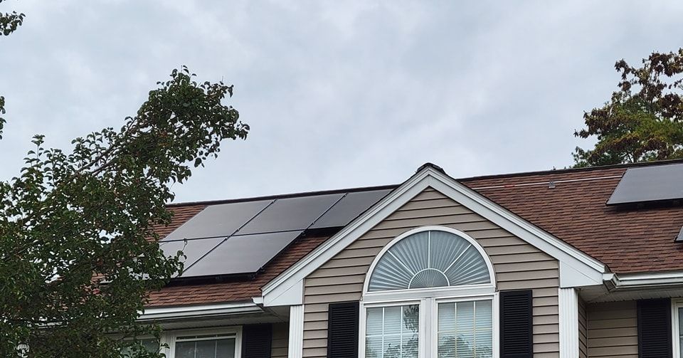 A house with solar panels on the roof and a large window