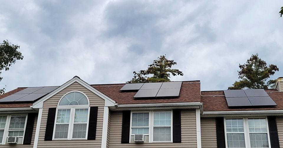 A house with a lot of windows and solar panels on the roof.