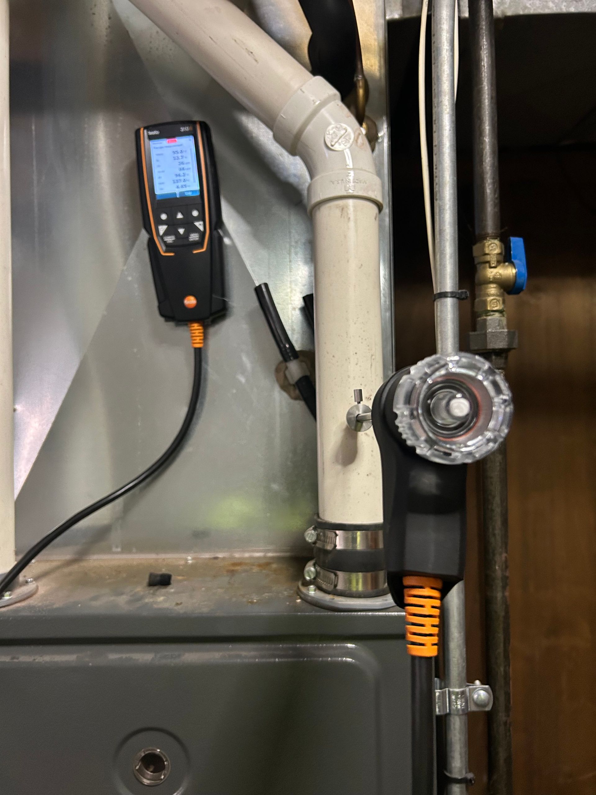 Gas furnace with connected measuring device and exhaust pipe.