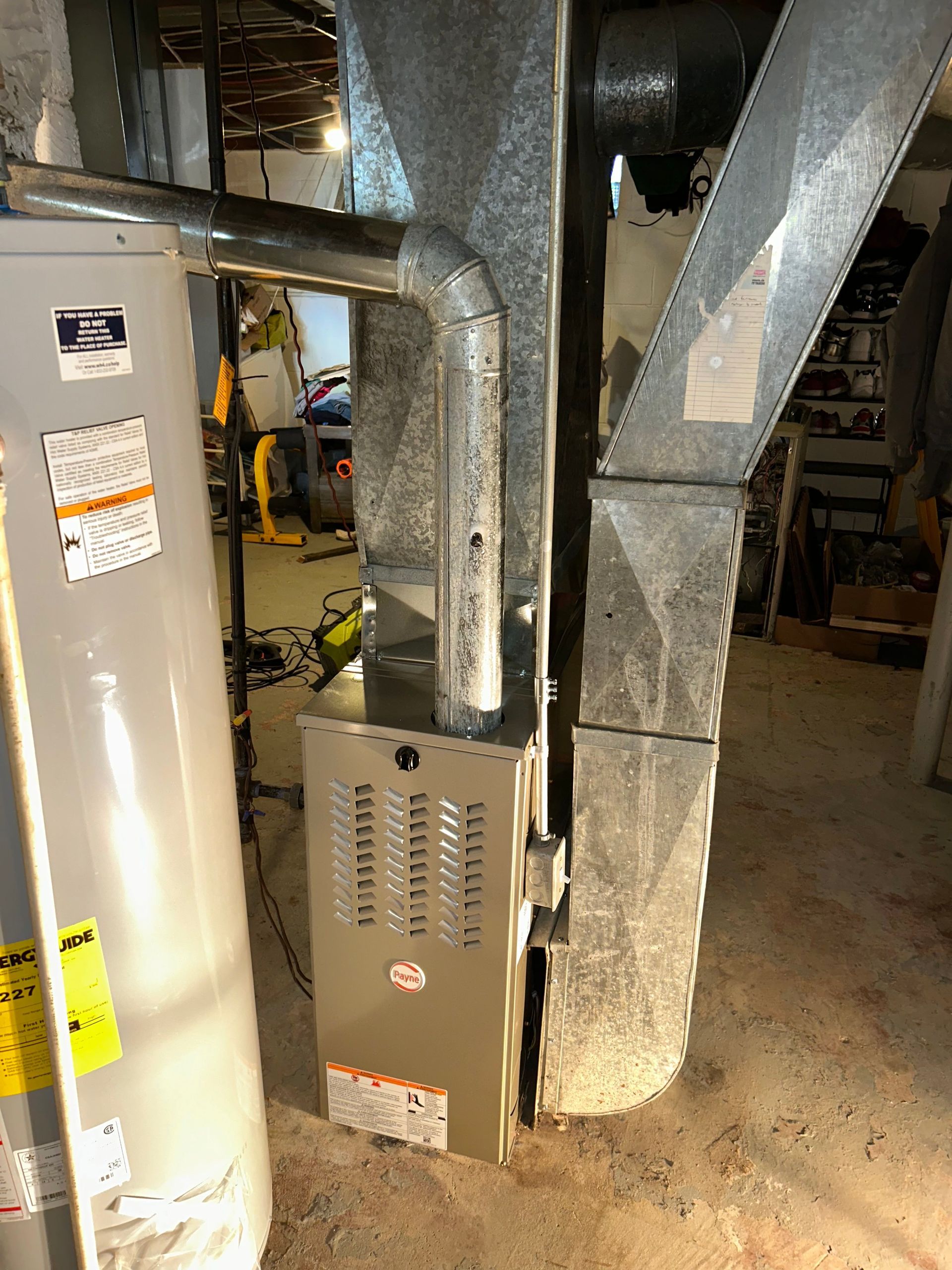Furnace and water heater in a basement. Metal ducts and pipes are visible.
