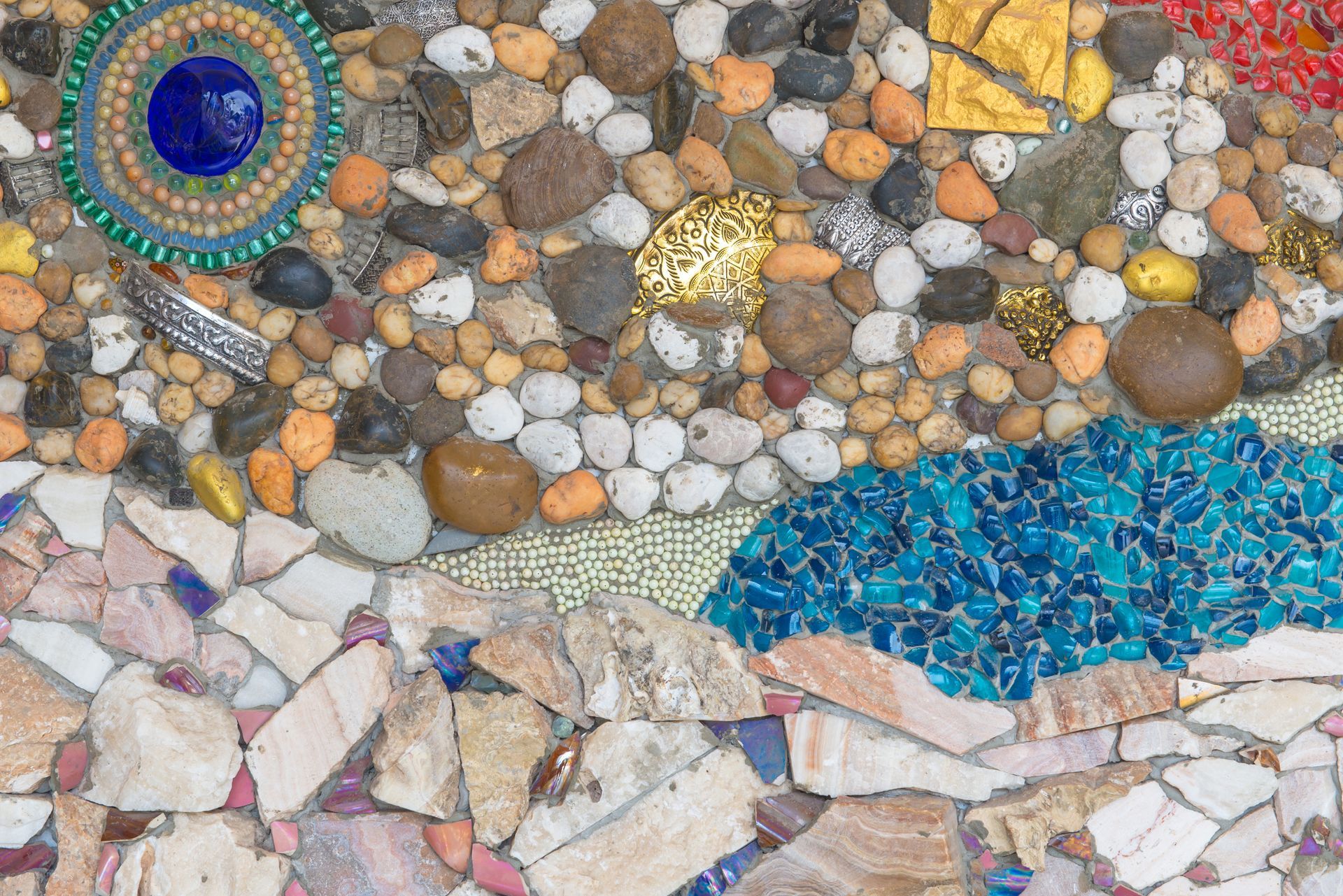 A close up of a mosaic of rocks on a wall.