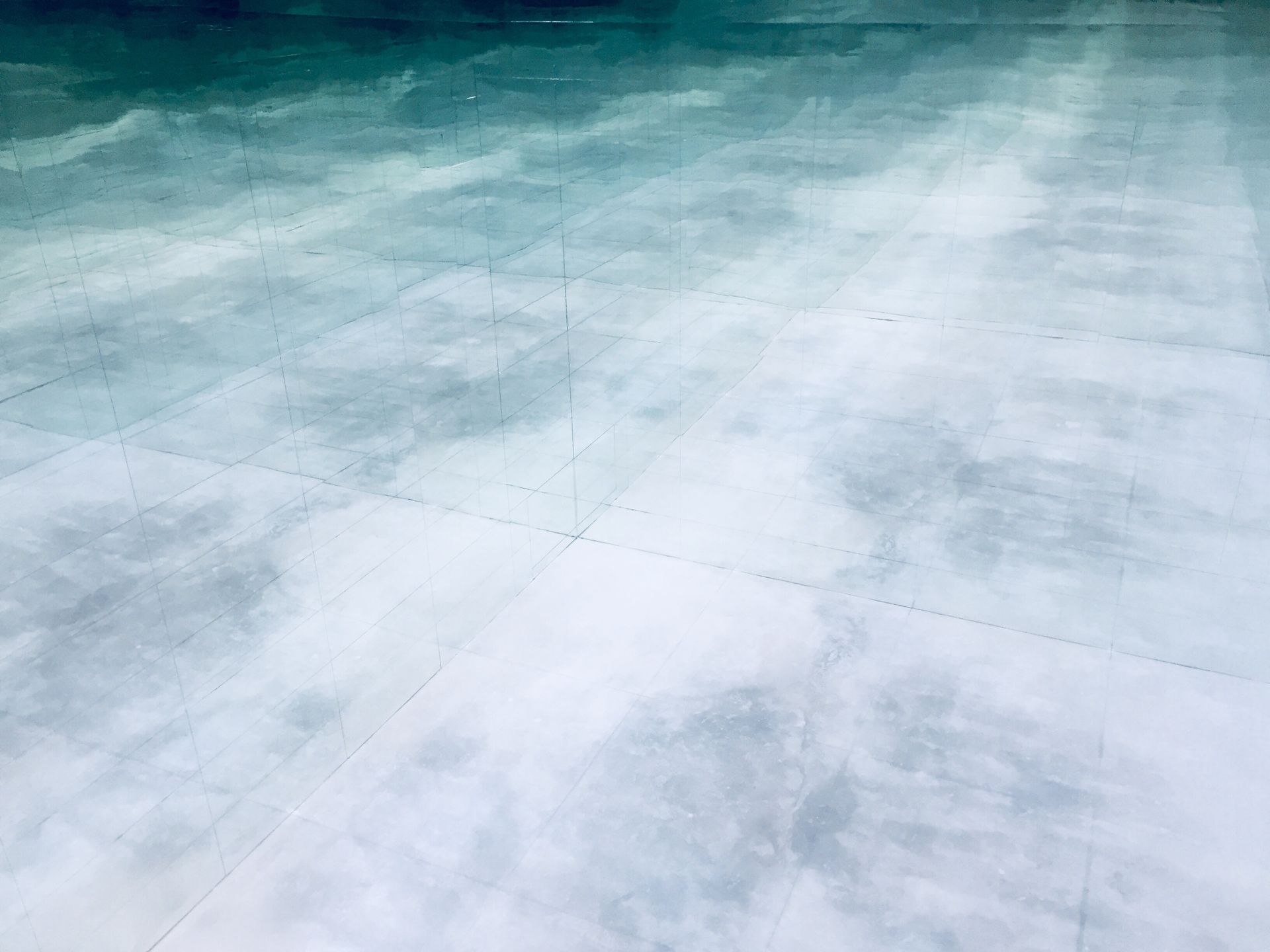 A close up of a concrete floor with a blue sky in the background.