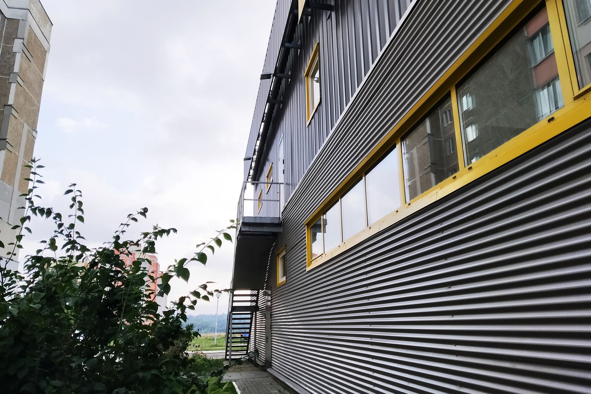 A building with yellow windows and stairs on the side