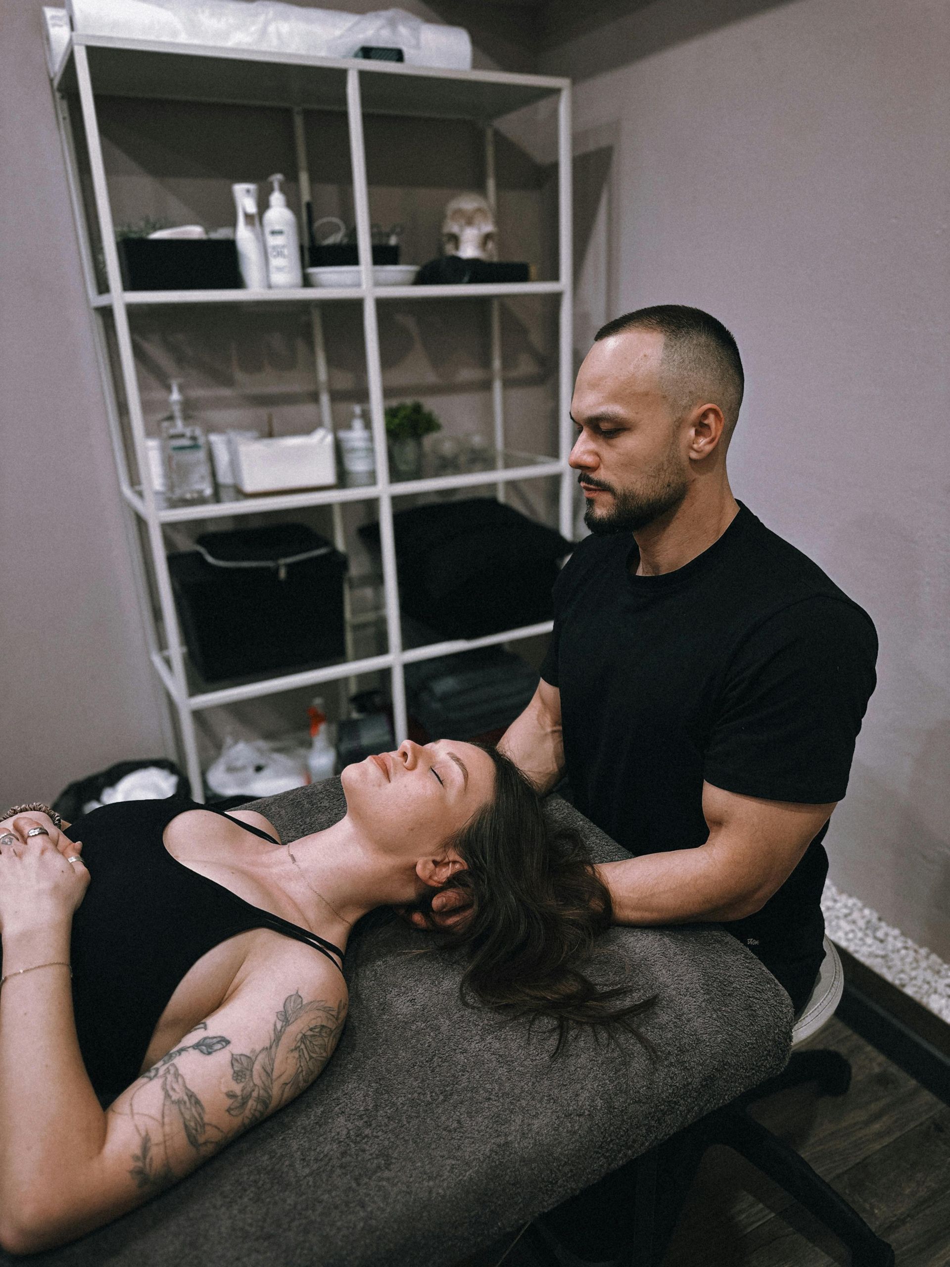 A man is giving a woman a chiropractic adjustment on a table.