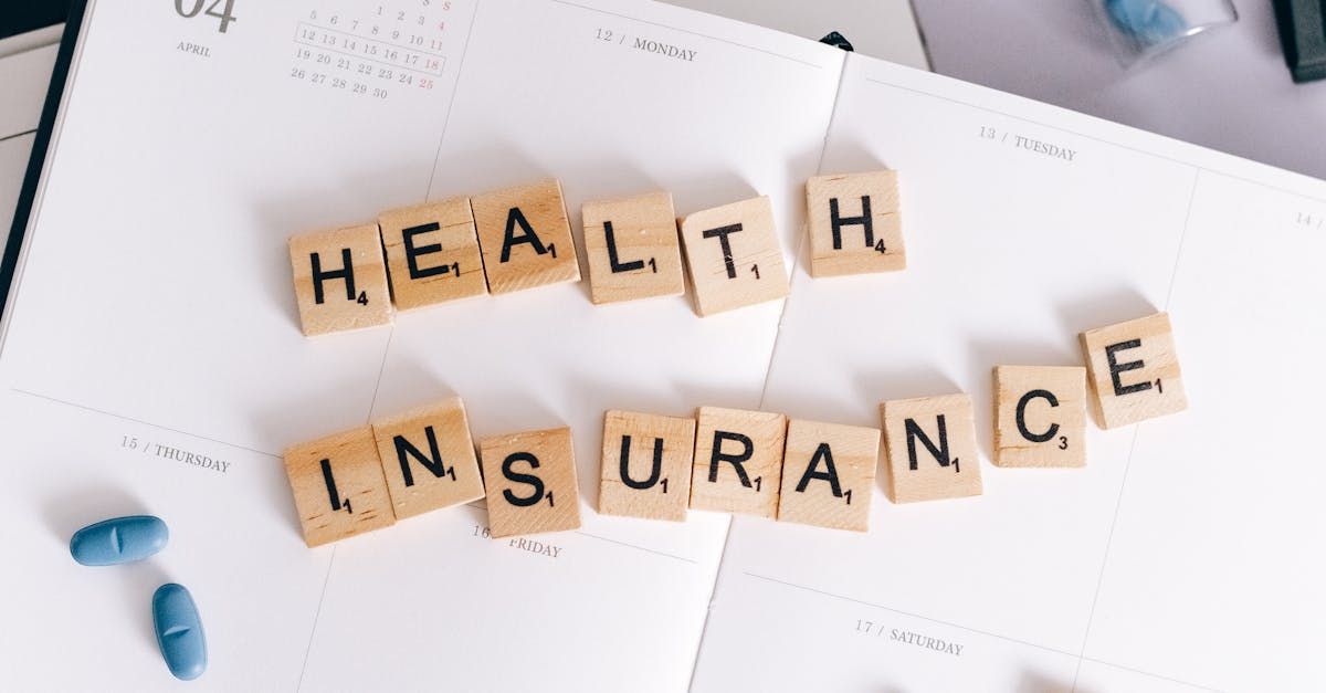 The word health insurance is written in scrabble tiles on a calendar.