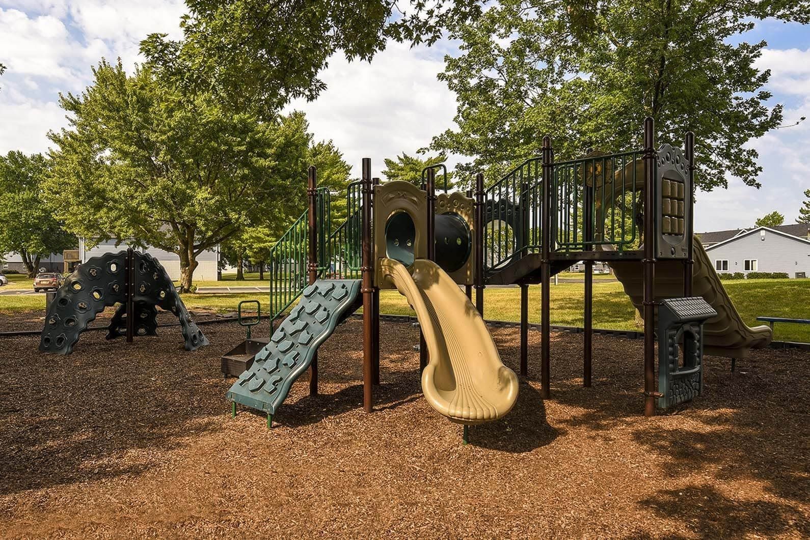 Outdoor playground with slides and climbing structures at a residential community.