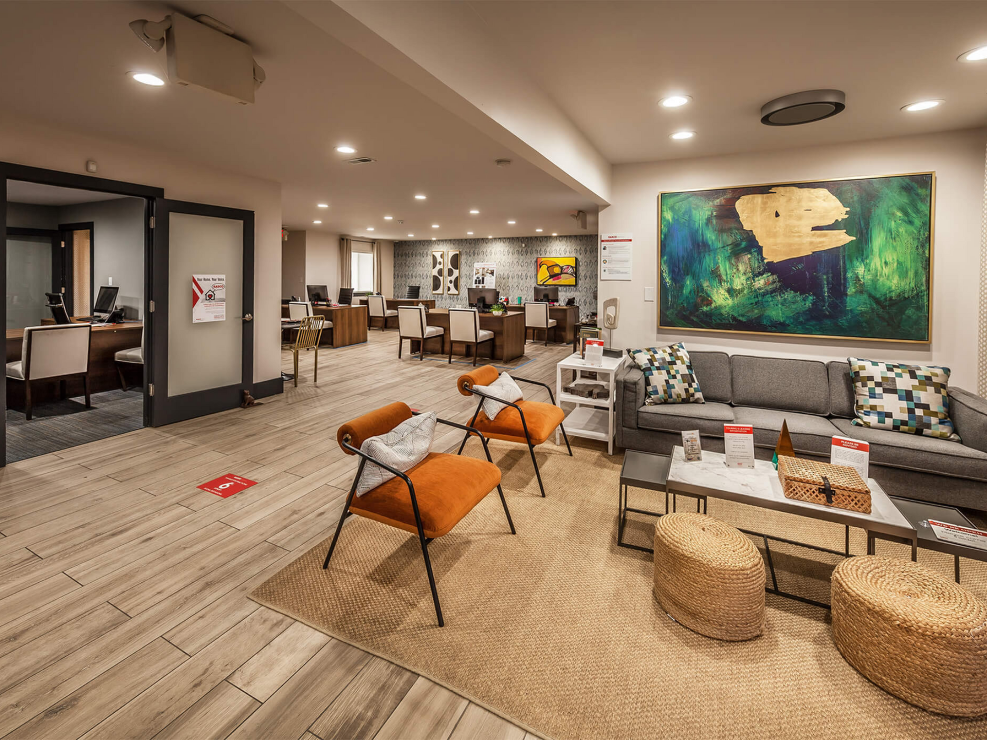 Interior of a modern apartment community lounge with seating area and desks.