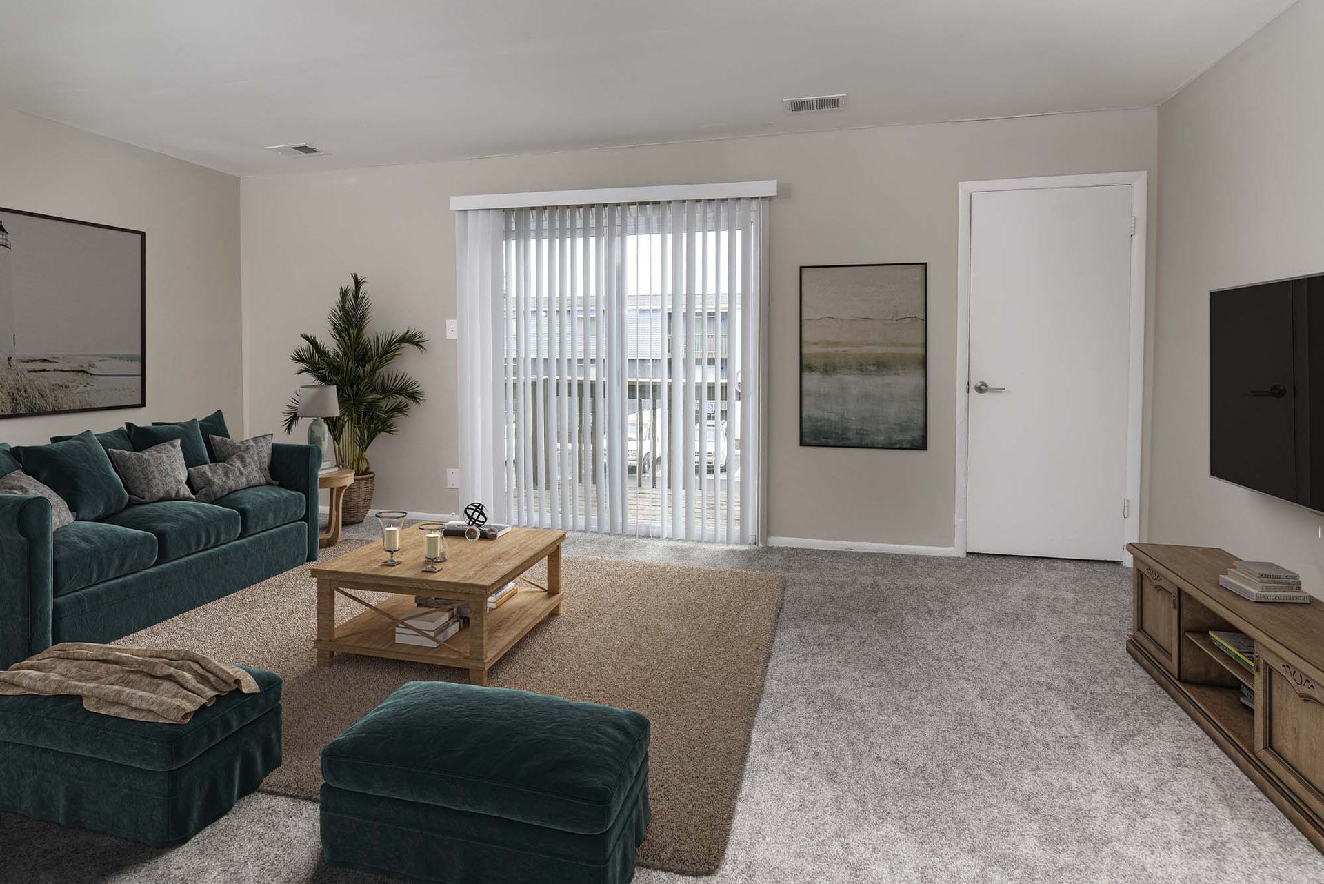 Living room in an apartment with teal sofa, ottoman, coffee table, and a sliding glass door with vertical blinds.
