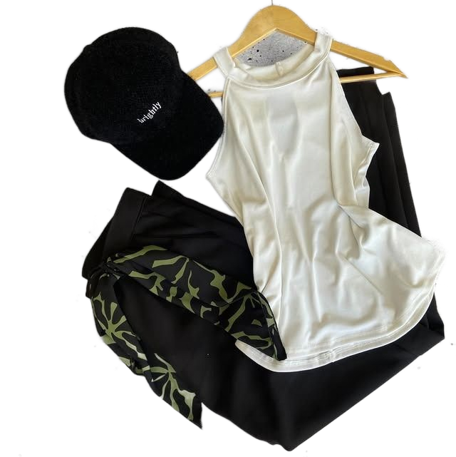 Mujer con top negro y pantalón gris, con auriculares y gafas