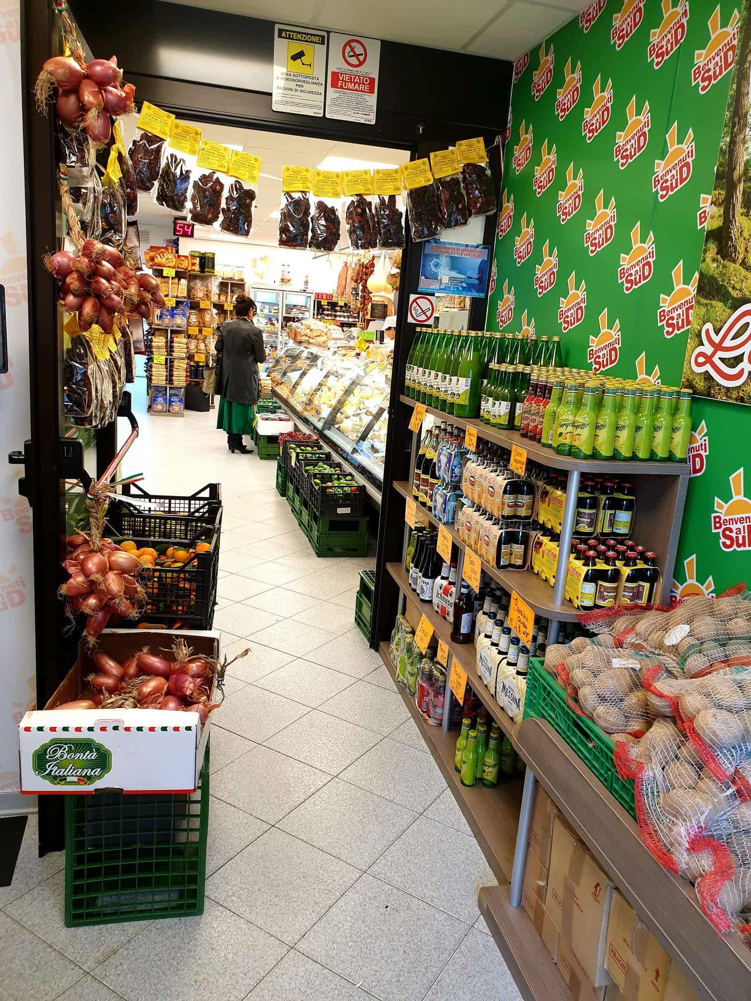Una donna sta camminando in un supermercato pieno di frutta e verdura.