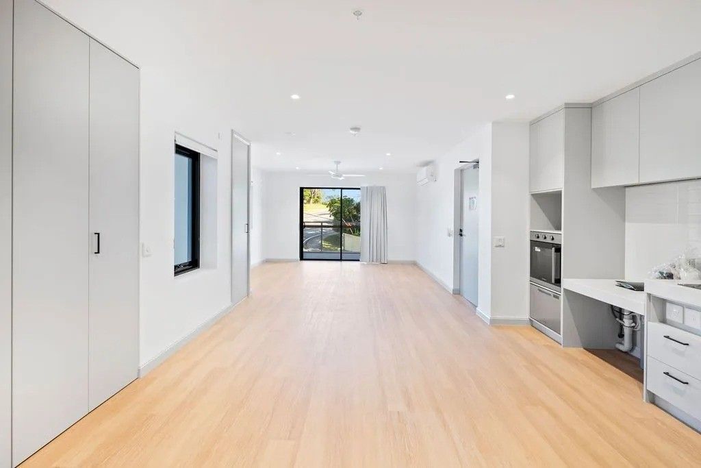Spacious, light-filled apartment with wood floors, built-in cabinetry, and access to a balcony.