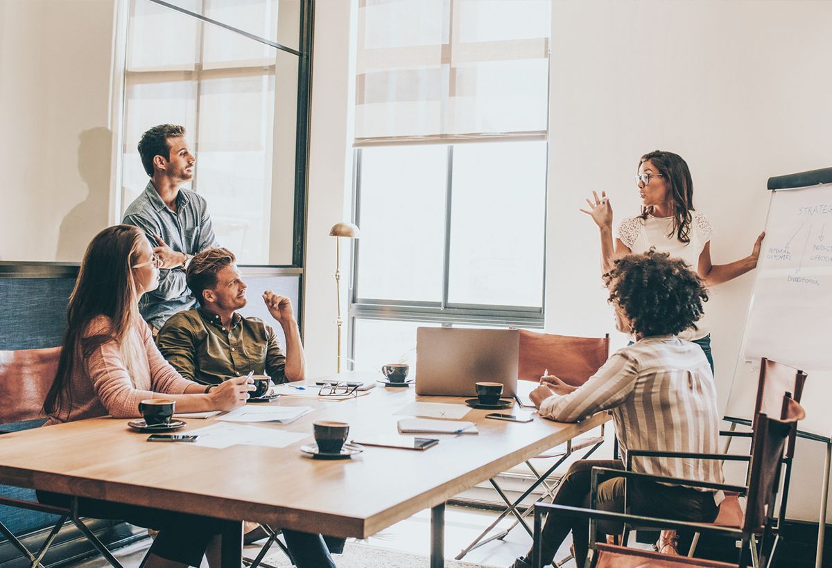 A group of people are sitting around a table having a meeting.