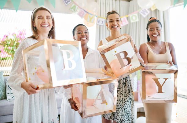 a group of friends and a mom posing at a photo booth rental during a baby shower