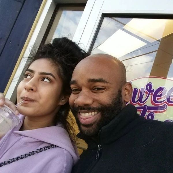 A man and a woman are posing for a picture in front of a sign that says welcome