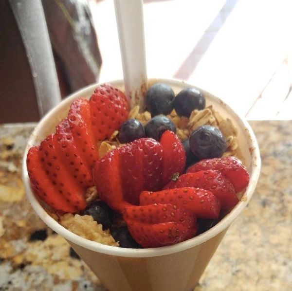 Strawberries and blueberries in a cup with a spoon