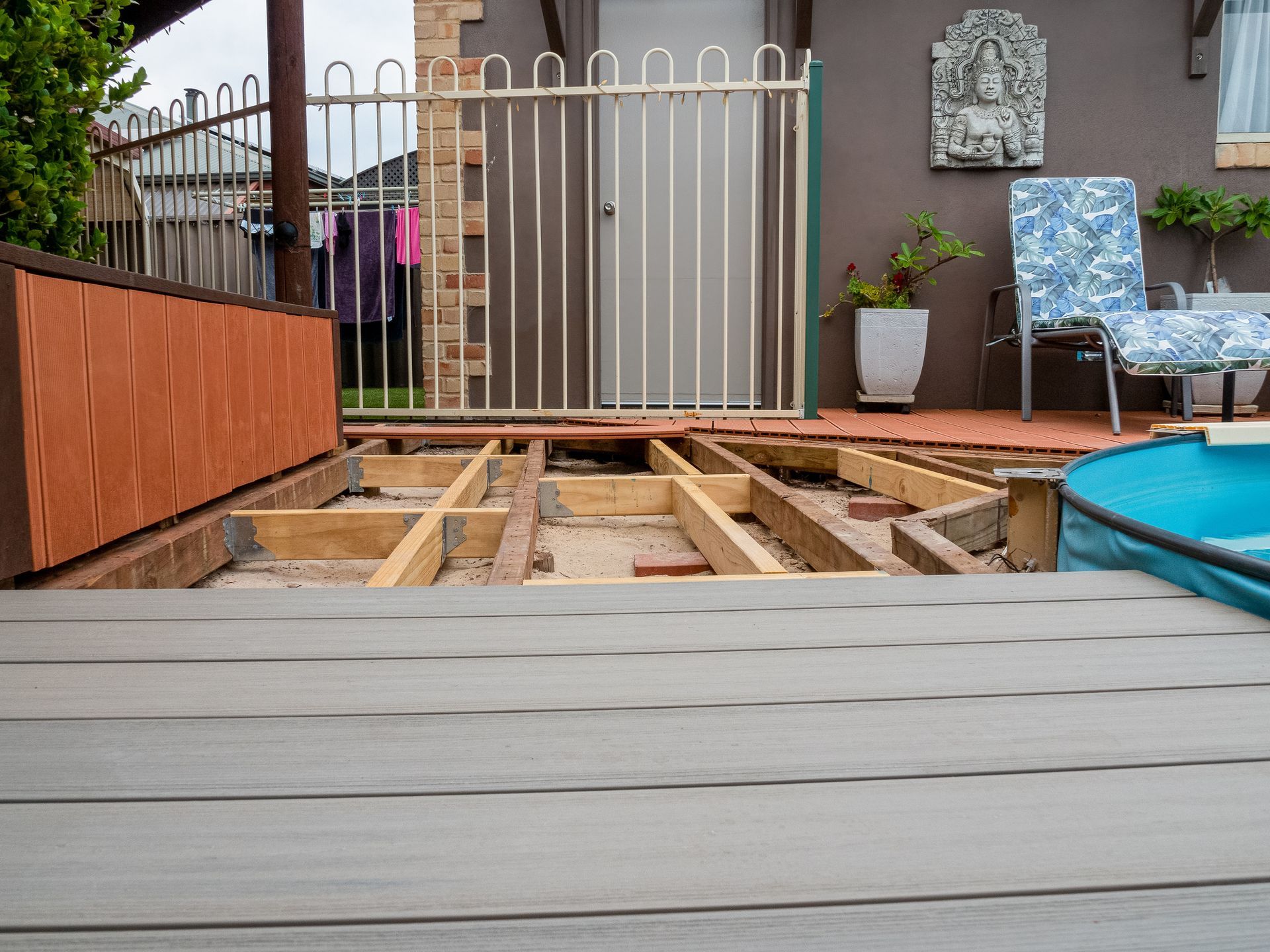 A wooden deck is being built in front of a house.