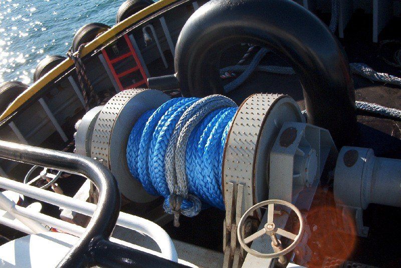 Blue and grey rope coiled on a winch, likely on a ship or boat.