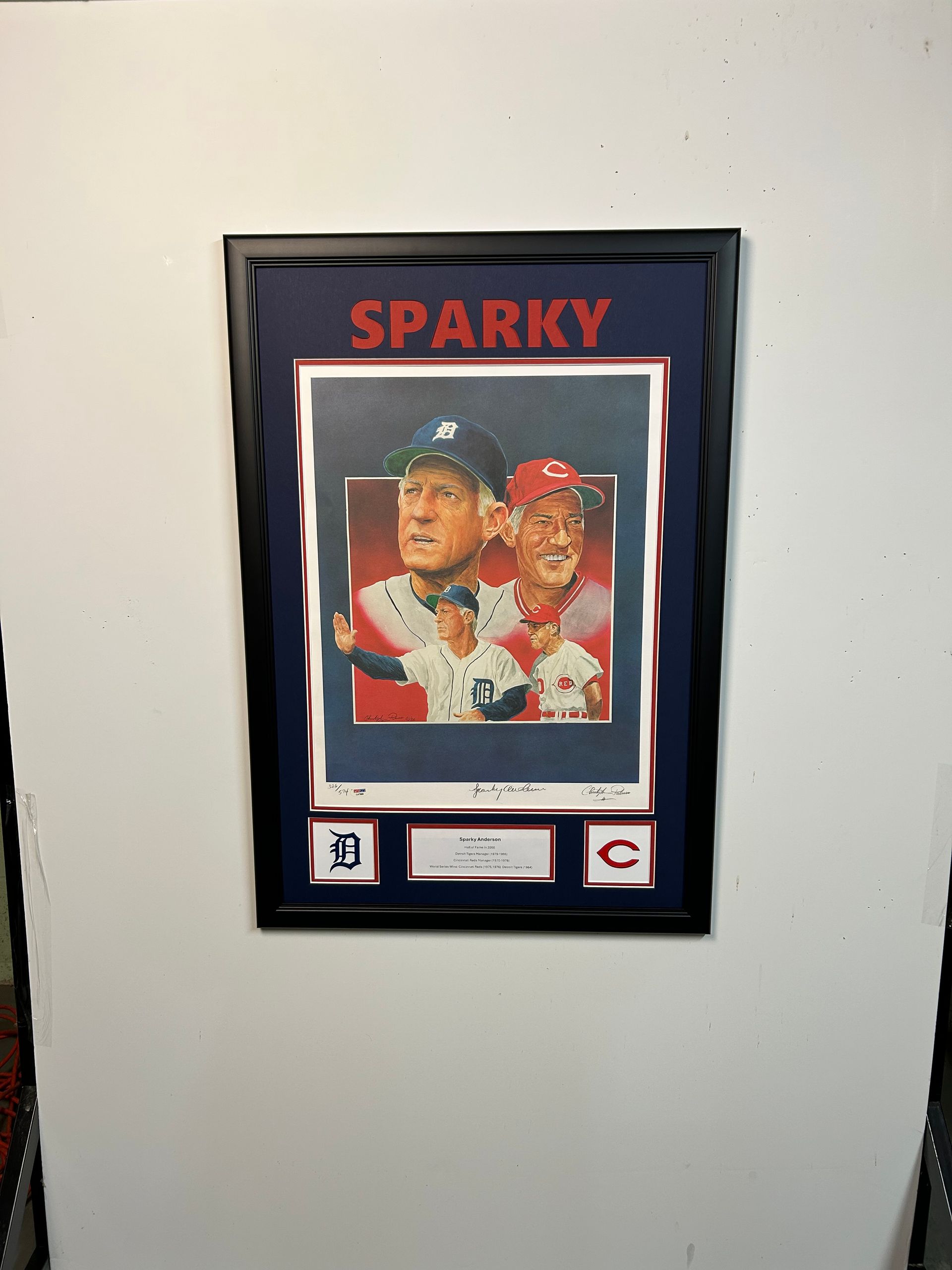 Framed sports poster labeled “SPARKY” with two baseball players on a white wall