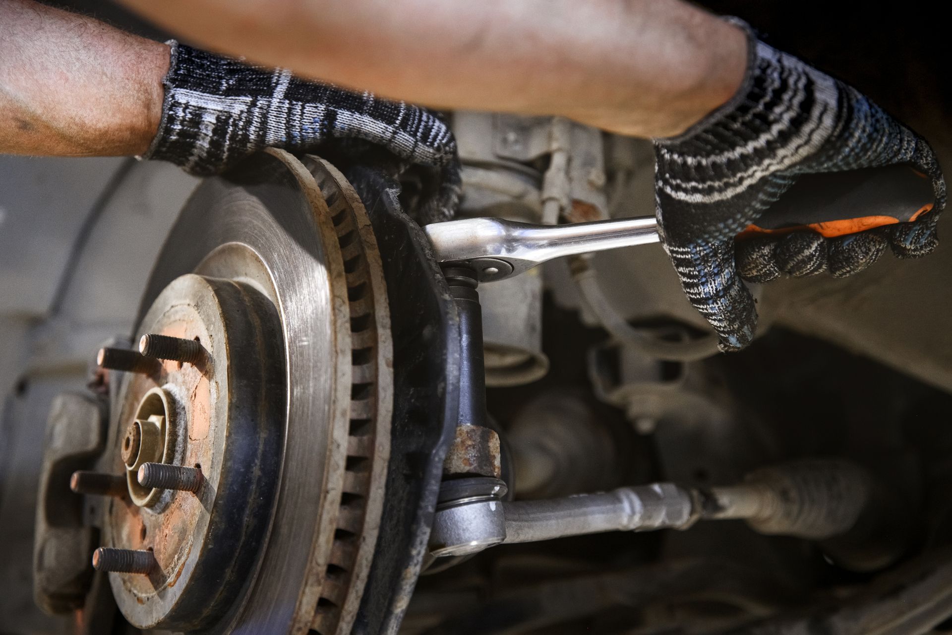 The hands of a mechanic hold a tool. Repair of the brake system of a car with a shallow depth of field.