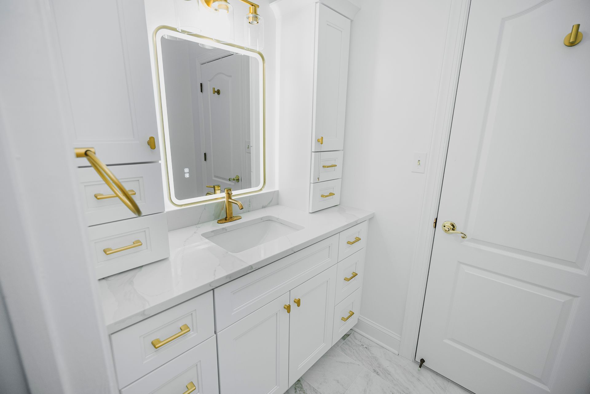 Modern bathroom remodel featuring white shaker cabinetry and brushed gold hardware by A-1 Renovations.