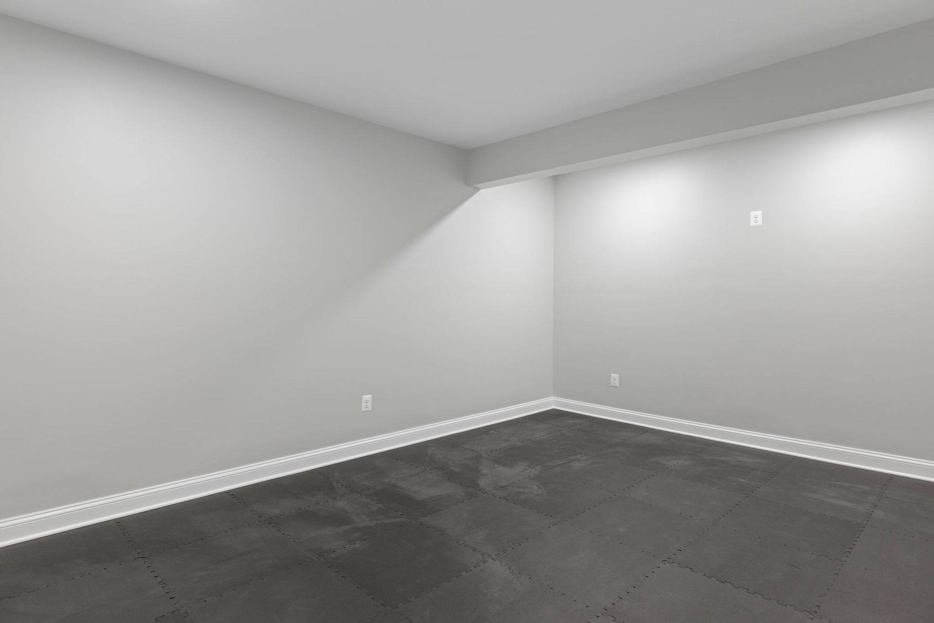 A newly renovated basement with new walls and fresh paint.