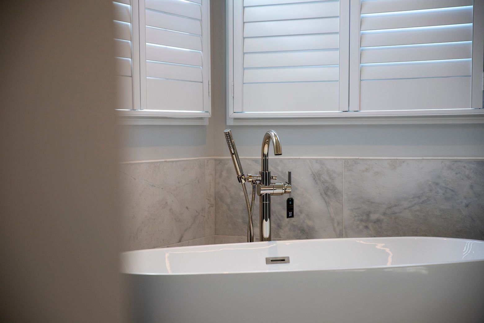 A clean, elegant master bath with a freestanding tub as the centerpiece.